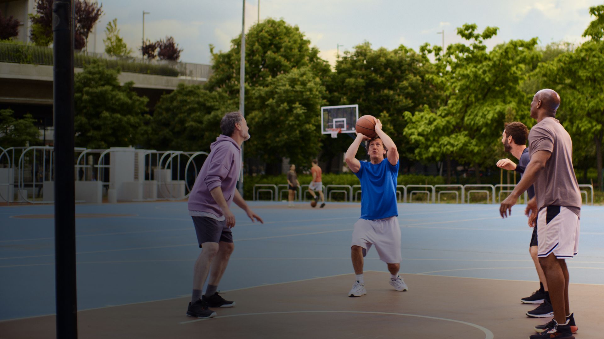Actor portrayal of a Camzyos® (mavacamten) patient and friends playing basketball.