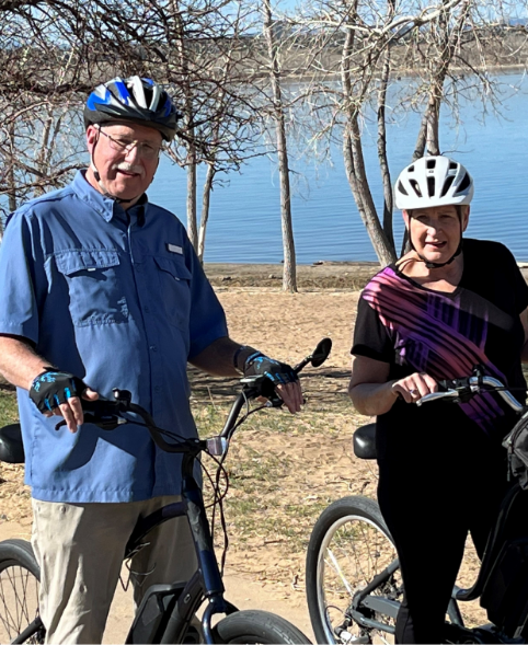 Mike, a Rx CAMZYOS® (mavacamten) patient, smiling with his wife, Amy on their bikes